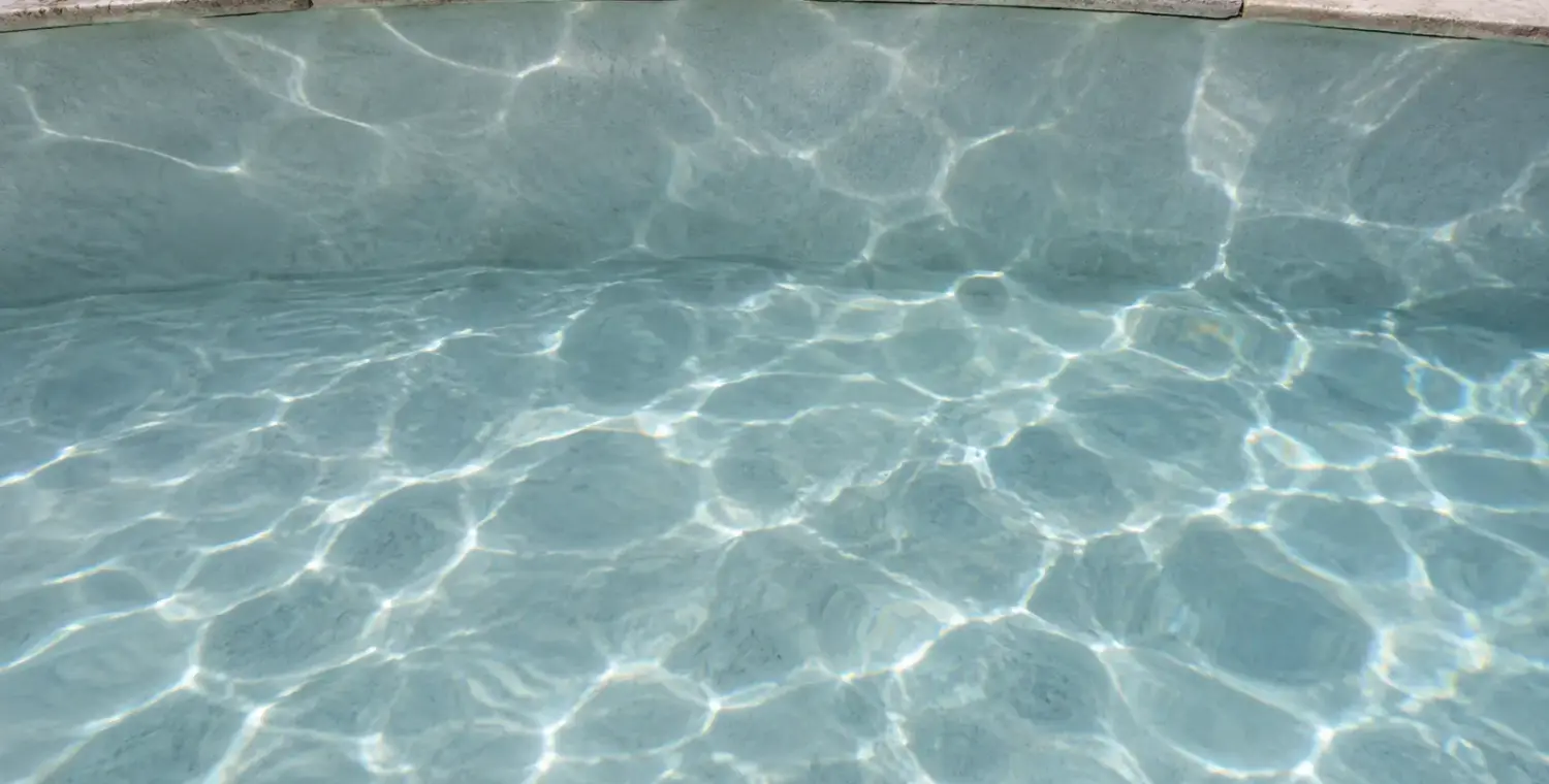 Close view of a plaster pool surface under clear water